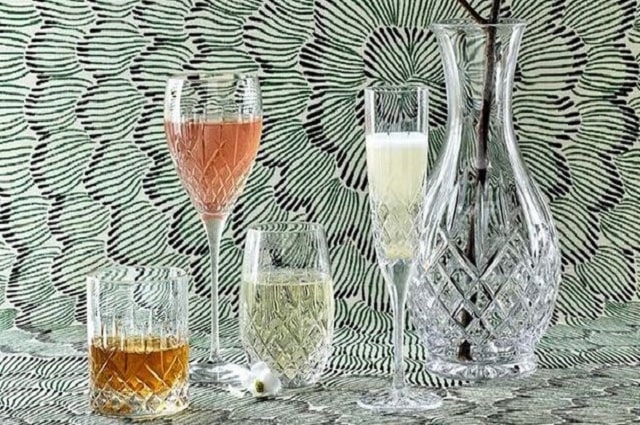 The Best Modern Crystal Wine Glasses, image of four crystal wine glasses and a crystal vase standing on a table.